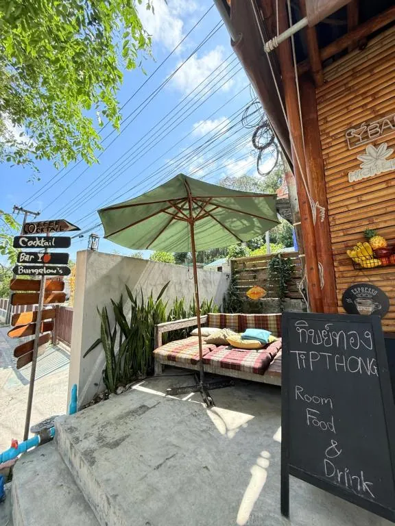 Entrada de TipThong Hut con su pizarra y el jardín