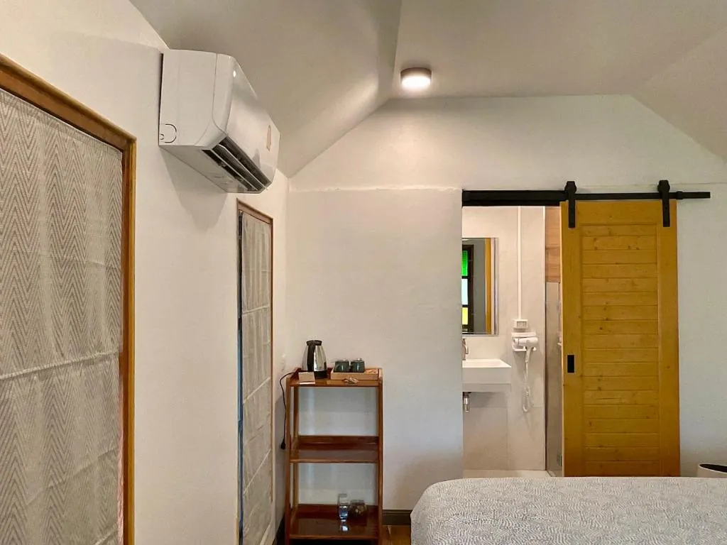 Room at TipThong Hut with air conditioning, kettle and sliding wooden bathroom door
